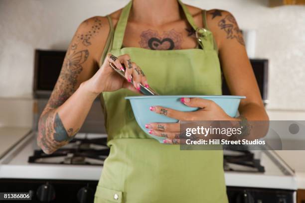 tattooed hispanic woman mixing batter - stirring stock pictures, royalty-free photos & images