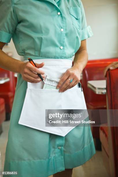 asian waitress putting order pad in apron - waitress booth stock pictures, royalty-free photos & images