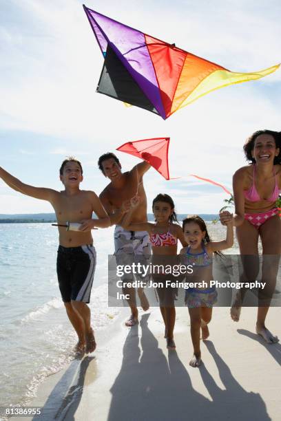 hispanic family flying kite at beach - the flying trunk stock pictures, royalty-free photos & images