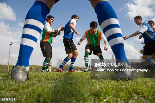 multi-ethnic men playing soccer - striped shirt stock pictures, royalty-free photos & images