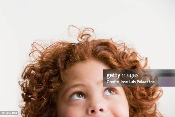 mixed race boy looking up - niños pensando fotografías e imágenes de stock