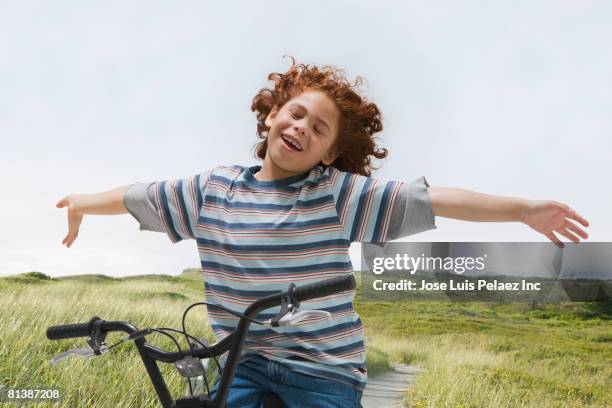 mixed race boy riding bicycle - hands free cycling stock pictures, royalty-free photos & images