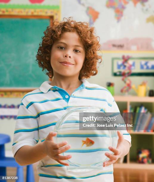 mixed race boy holding fish bowl - swimming classroom stock-fotos und bilder