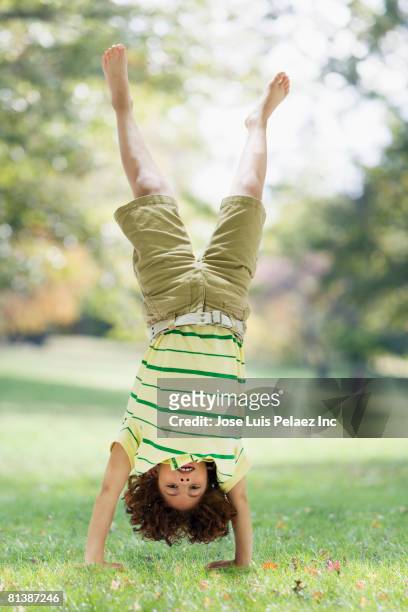 mixed race boy performing handstand - boy handstand stock pictures, royalty-free photos & images