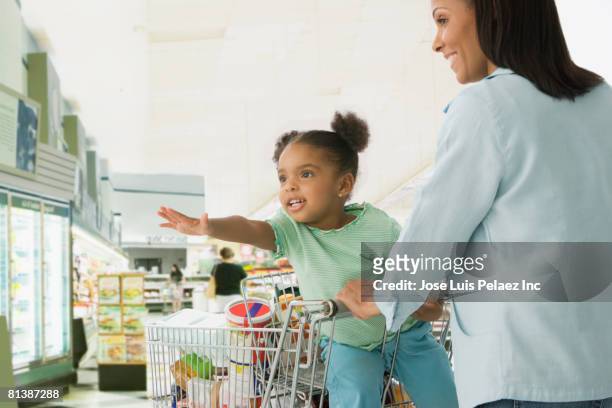 african mother and daughter shopping in grocery store - girl reaching stock pictures, royalty-free photos & images