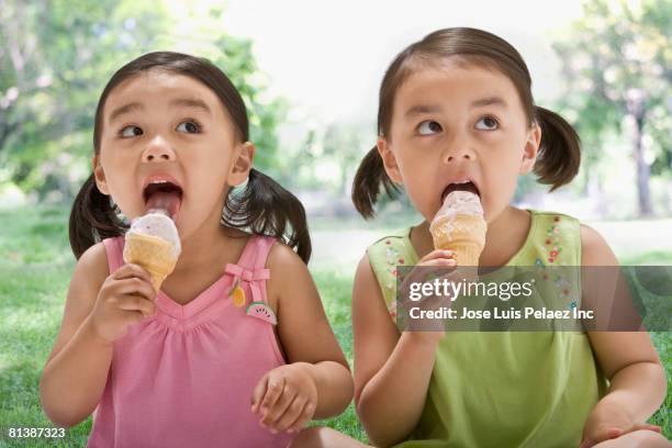 asian sisters eating ice cream cones - solo bambine femmine foto e immagini stock