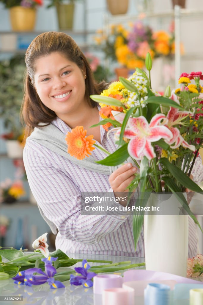 Hispanic female florist arranging flowers