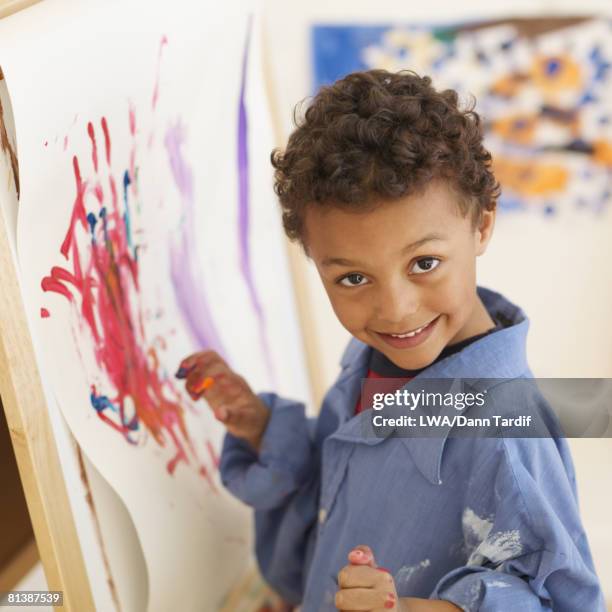 african boy painting at easel - school boy art stock pictures, royalty-free photos & images