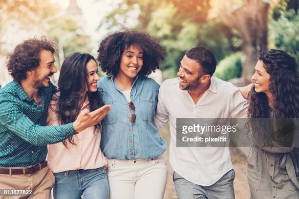group of friends talking and laughing - arm in arm stock pictures, royalty-free photos & images