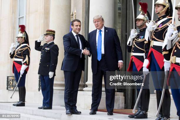 Emmanuel Macron, France's president, left, and U.S. President Donald Trump, shake hands while posing for photographs at the Elysee Palace in Paris,...
