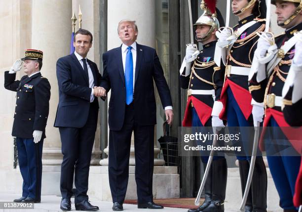 Emmanuel Macron, France's president, center left, and U.S. President Donald Trump, center right, shake hands while posing for photographs at the...