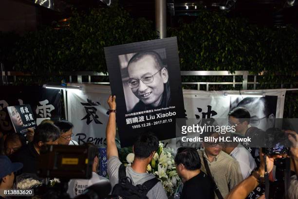 People mourn the death of jailed Chinese Nobel Peace laureate Liu Xiaobo during a demonstration outside the Chinese liaison office on July 13, 2017...