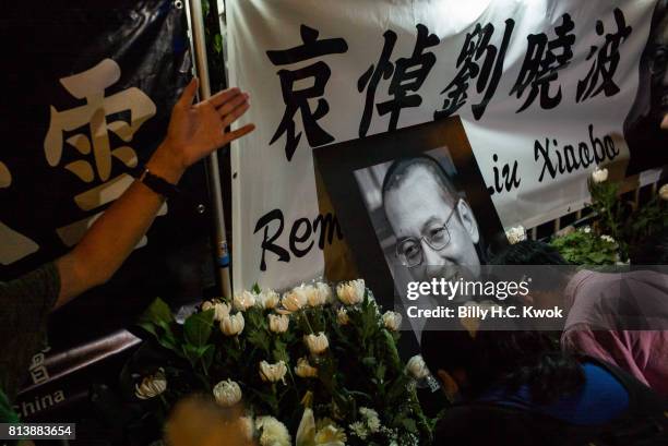 People mourn the death of jailed Chinese Nobel Peace laureate Liu Xiaobo during a demonstration outside the Chinese liaison office on July 13, 2017...