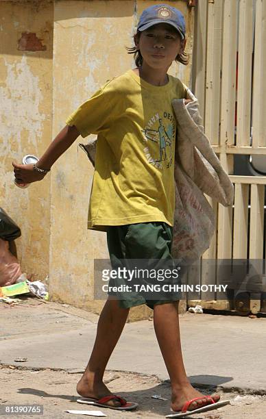 Cambodia-economy-labour-poverty-child, by Lucie Lautredou A Cambodian scarvenger carries a can along a street in Phnom Penh on March 11, 2008. Doctor...