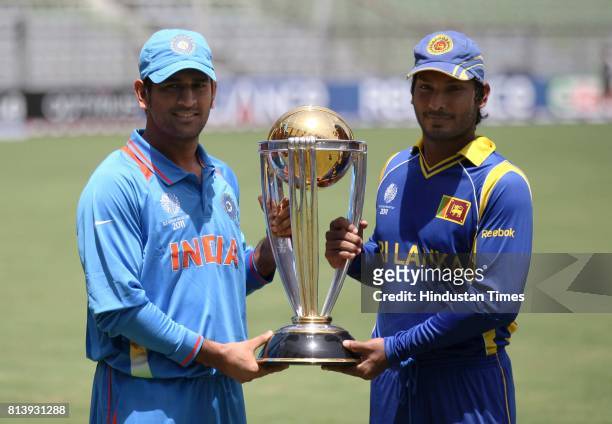 India's captain Mahendra Singh Dhoni and Sri Lanka captain Kumar Sangakkara poses with cricket world cup trophy ahead of their ICC Crciket World Cup...