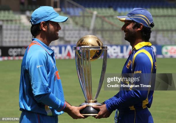 India's captain Mahendra Singh Dhoni and Sri Lanka captain Kumar Sangakkara poses with cricket world cup trophy ahead of their ICC Crciket World Cup...