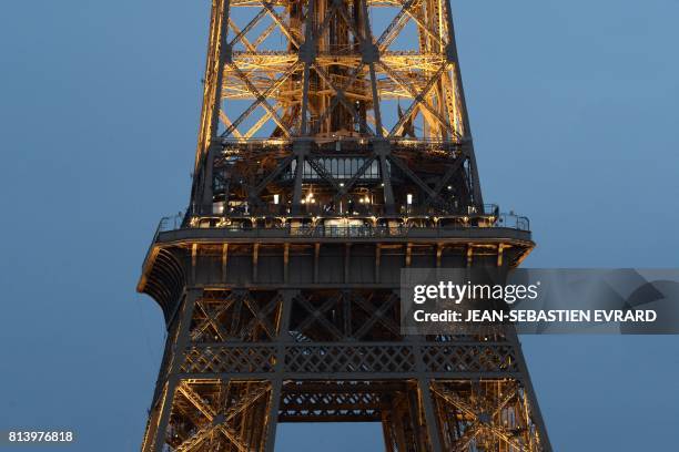 People stand outside the restaurant 'Le Jules Verne' on the second floor of the Eiffel Tower in Paris on July 13 where the US President Donald Trump...