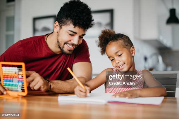 cute girl is doing math with a help of her dad - dad homework stock pictures, royalty-free photos & images