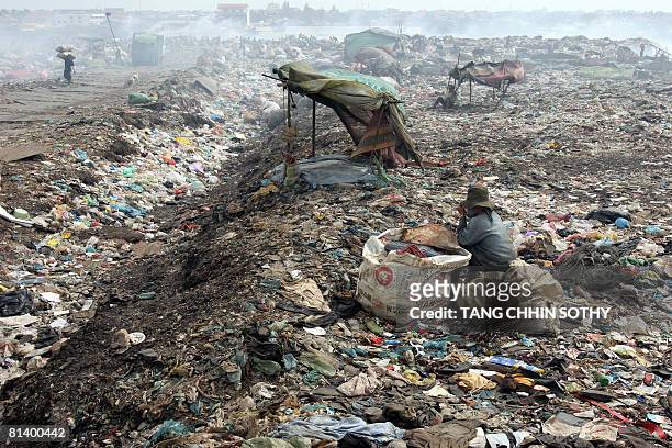 Cambodia-economy-labour-poverty-child, by Lucie Lautredou A Cambodian scarvenger sit at a rubbish damp in Phnom Penh on January 4, 2008. Doctor Tuy...