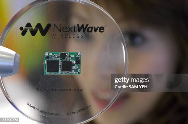 Woman looks at a chip-set made by US company NextWave Wireless is on display at a WiMAX exhibition at the Taipei World Trade Centre June 4, 2008....