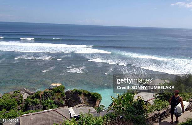 Foreign tourist heads to surf at the Uluwatu beach in Jimbaran on the resort island of Bali on June 4 2008. The number of foreign tourists visiting...