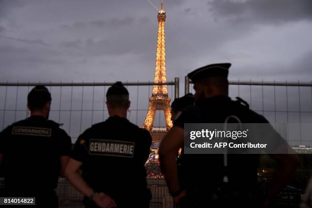 French gendarmes look towards the Eiffel Tower in Paris on July 13 as US President Donald Trump and French President Emmanuel Macron attend a dinner...