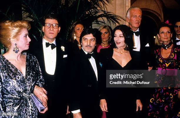 Catherine Deneuve, Yves Siant Laurent, Emmanuel Ungaro, Anouk Aimee, and Hubert de Givenchy attend a party 1990 in Paris, France.