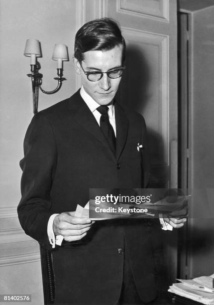 French fashion designer Yves Saint Laurent reading trelegrams of congratulation after the success of his new spring and summer collection for Dior,...