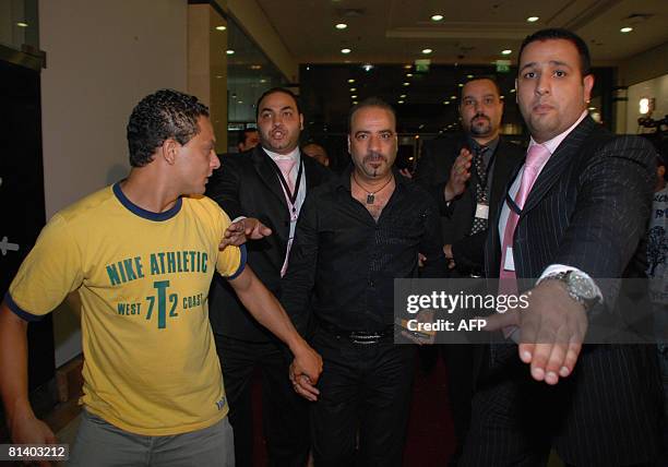 Egyptian actor Mohammad Saad is flanked by bodyguards upon his arrival at a movie theatre in Cairo to attend the premiere of his new film 'Cabaret',...