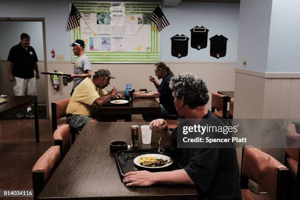 Men eat at a soup kitchen operated by the American Rescue Workers in the struggling city of Williamsport, which has recently seen an epidemic of...
