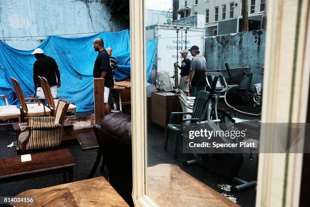 Men move furniture at a sale run by the American Rescue Workers in the struggling city of Williamsport, which has recently seen an epidemic of opioid...