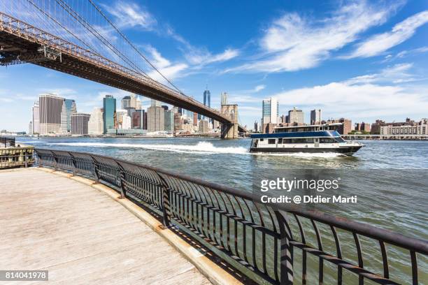 ferry in new york city in front of manhattan business district. - brooklyn bridge photos et images de collection
