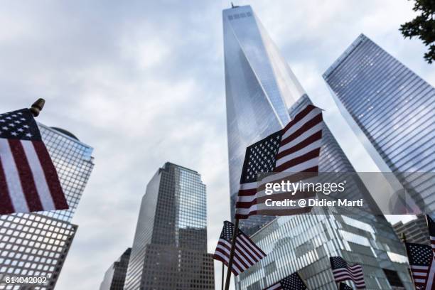 american flag in front of the one world world trade center in new york city - capitalismo foto e immagini stock