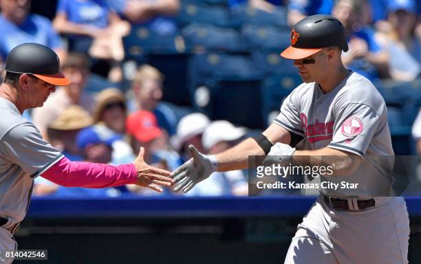 Baltimore Orioles' Chris Davis is congratulated by third base coach Bobby Dickerson after hitting a solo home run in the second inning against the...