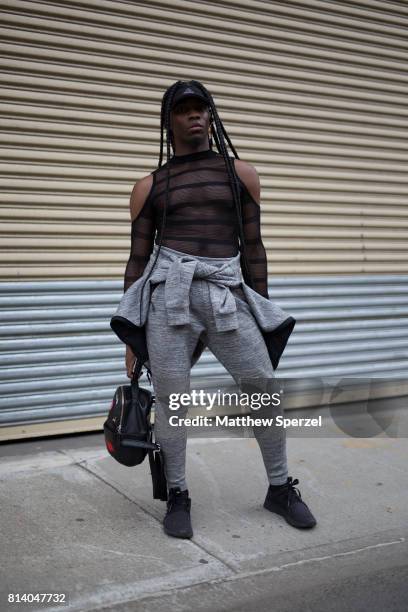 Guest is seen attending General Idea & Raun LaRose during Men's New York Fashion Week wearing a black mesh top with grey sweatsuit on July 13, 2017...