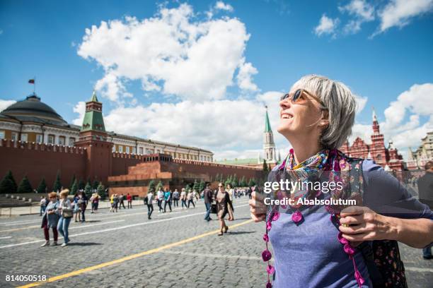 porträt einer schönen reife frau genießt den roten platz in moskau, russland - white square moscow stock-fotos und bilder