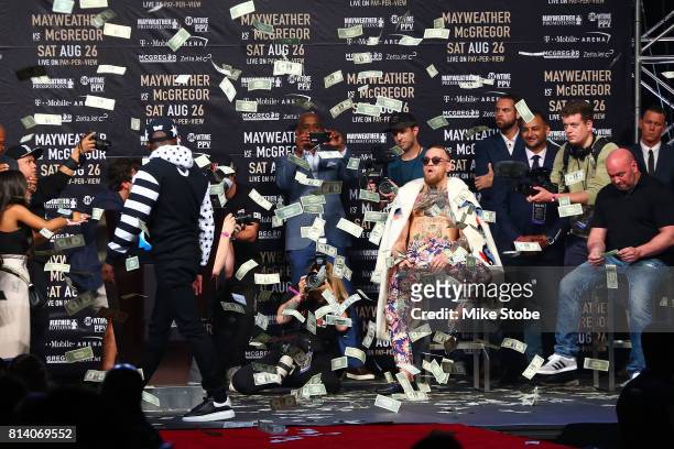 Floyd Mayweather Jr. Looks on as money rains down on Conor McGregor during the Floyd Mayweather Jr. V Conor McGregor World Press Tour event at...