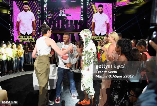 Host Russell Wilson accepts the King of Swag award from WNBA player Breanna Stewart, TV personality Nick Cannon, MLB player Prince Fielder, World Cup...