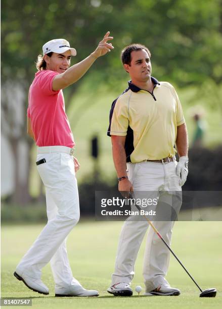 Camilo Villegas offer's a tip to playing partner NASCAR driver Juan Montoya during the Pro-Am round of the Stanford St. Jude Championship at TPC...
