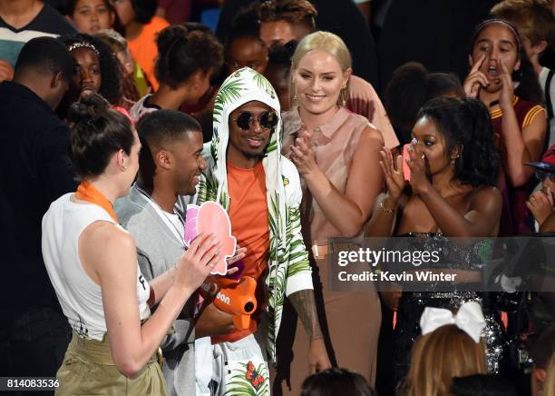 Host Russell Wilson accepts the King of Swag award from WNBA player Breanna Stewart, TV personality Nick Cannon, World Cup skiier Lindsey Vonn, and...