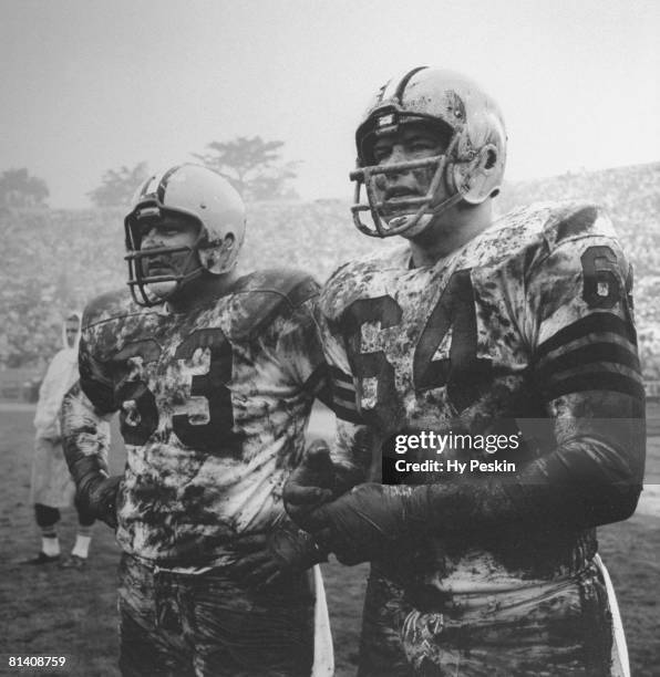 Football: Green Bay Packers Fuzzy Thurston and Jerry Kramer on sidelines, covered in mud during game with rain, weather vs San Francisco 49ers, San...