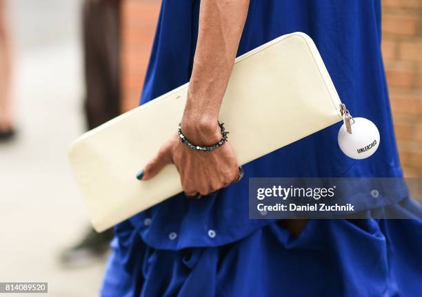 Guest is seen with a white clutch outside the General Idea show during New York Fashion Week: Men's S/S 2018 at Skylight Clarkson Sq on July 13, 2017...