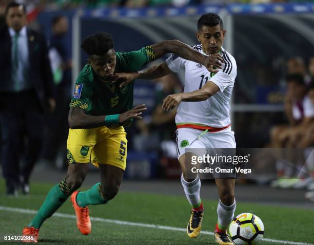 Elias Hernandez of Mexico fights for the ball with Alvas Powell of Jamaica during a Group C match between Mexico and Jamaica as part of CONCACAF Gold...
