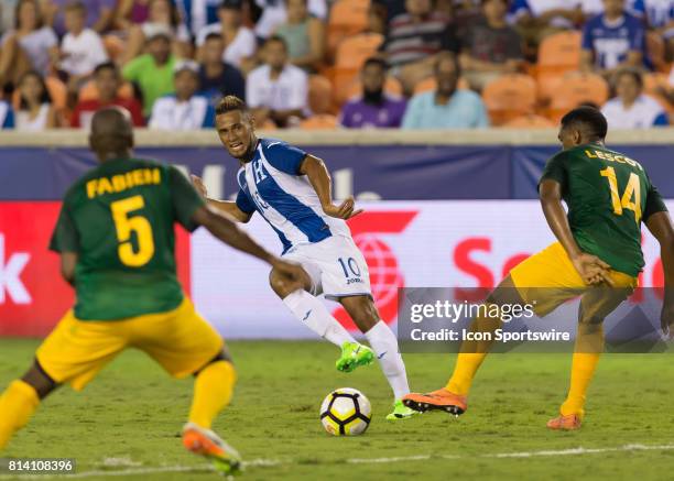 Honduras midfielder Alex Lopez sends the ball between French Guiana midfielder Cedric Fabien and French Guiana defender Gregory Lescot during the...