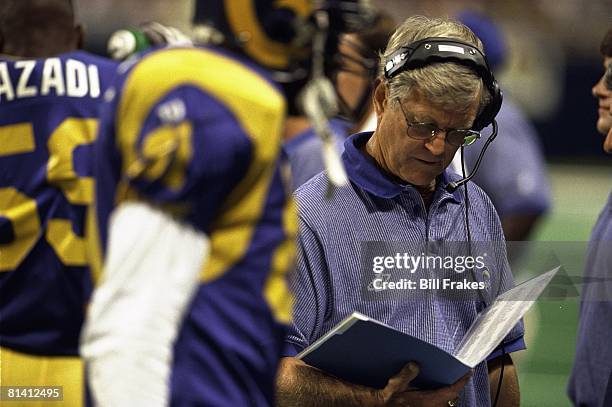 Football: Closeup of St, Louis Rams coach Dick Vermeil on sidelines wearing headset and looking at playbook during game vs New York Giants, St,...