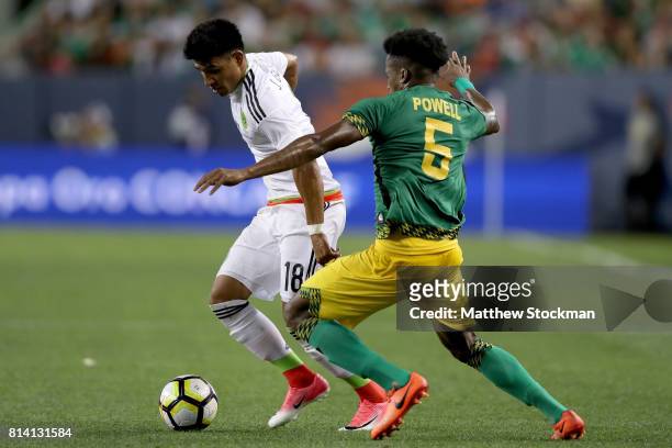 Jesus Gallardo of Mexico attempts to get past Alvas Powell of Jamaica during the 2017 CONCACAF Gold Cup at Sports Authority Field at Mile High on...