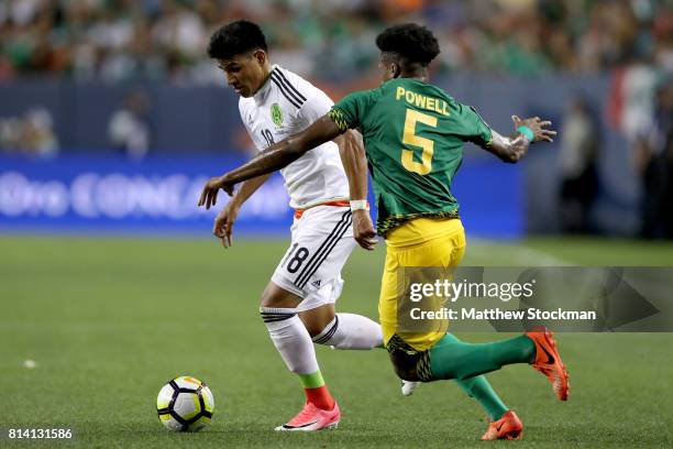 Jesus Gallardo of Mexico attempts to get past Alvas Powell of Jamaica during the 2017 CONCACAF Gold Cup at Sports Authority Field at Mile High on...