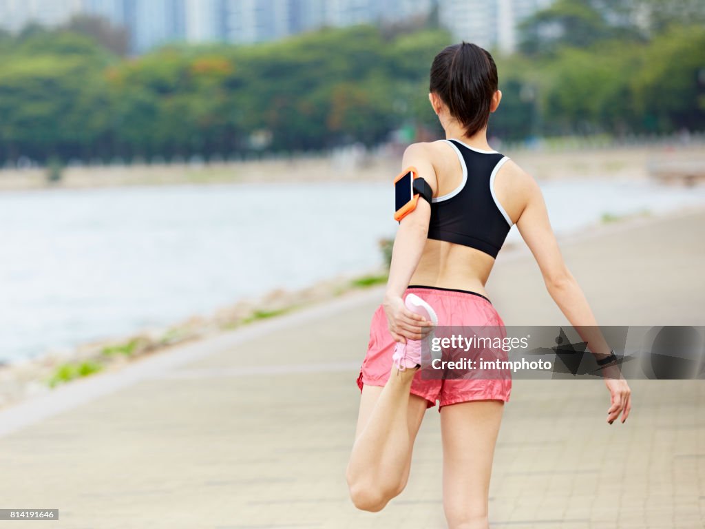 Young asian woman stretching leg before exercise