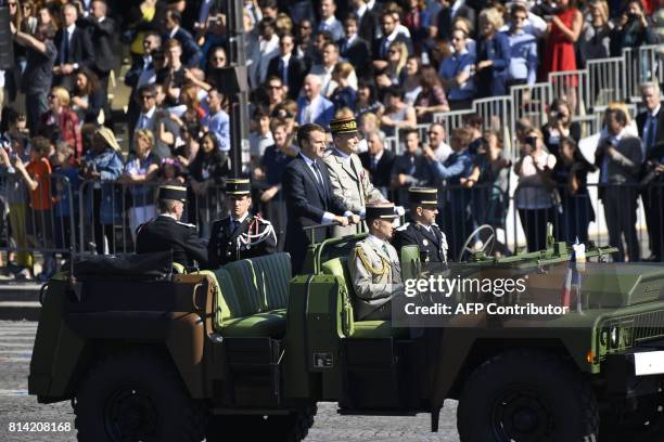 French President Emmanuel Macron and Chief of the Defence Staff of the French Army General Pierre de Villiers arrive in a command car for the annual...