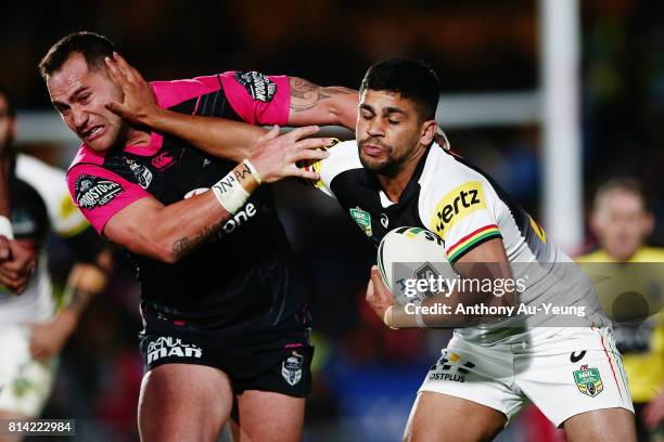 Tyrone Peachey of the Panthers fends against Bodene Thompson of the Warriors during the round 19 NRL match between the New Zealand Warriors and the...